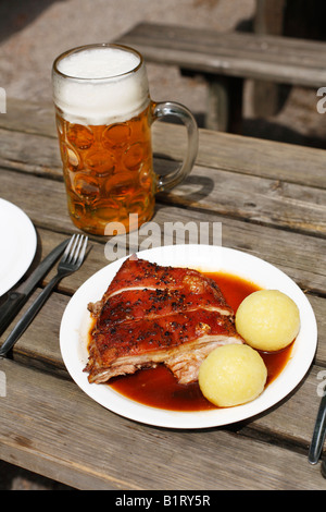 Schwein Spanferkel mit Knödel und eine Masse von Bier serviert in einem Biergarten in Taxisgarten, München, Bayern, Deutschland, Europa Stockfoto