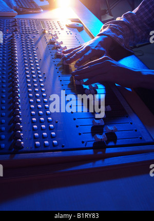 Händen der Tontechniker anpassen die Regulatoren von einer professionellen Mixer-Einheit Stockfoto