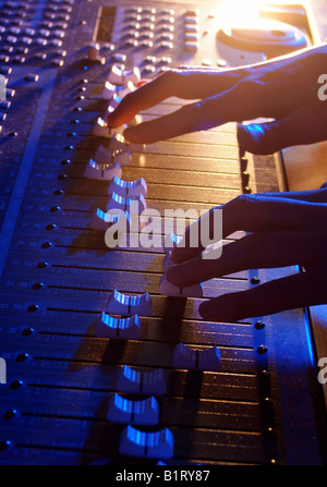 Händen der Tontechniker anpassen die Regulatoren von einer professionellen Mixer-Einheit Stockfoto