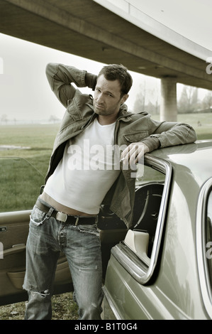 31 Jahre alter Mann verkleidet als James Dean, ein Auto gelehnt Stockfoto