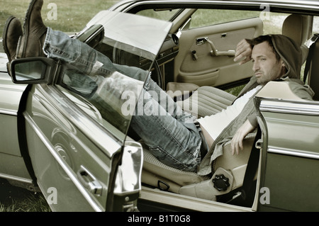 31 Jahre alter Mann verkleidet als James Dean im Auto Stockfoto