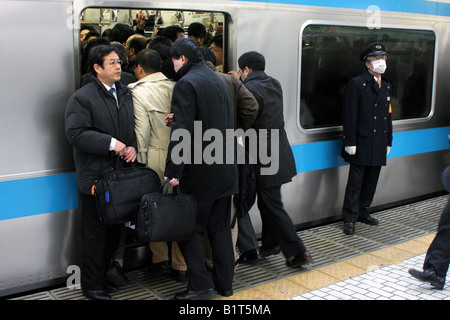 Gehaltsempfänger auf belebten Züge auf der Yamanote-Linie im morgendlichen Berufsverkehr Stockfoto