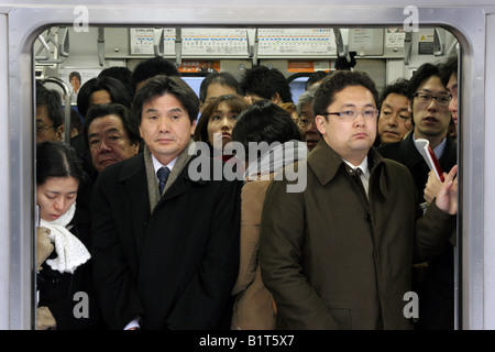 Gehaltsempfänger auf belebten Züge auf der Yamanote-Linie im morgendlichen Berufsverkehr Stockfoto