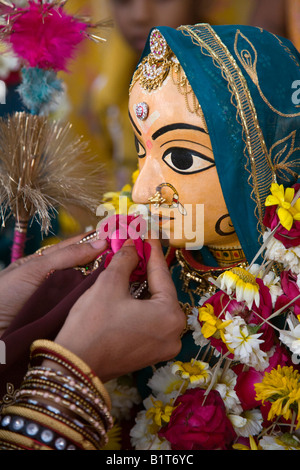 Eine Rajasthani-Frau macht eine Blume Offerting Shivas Gattin PARVATI auf dem GANGUR FESTIVAL UDAIPUR RAJASTHAN Indien Stockfoto