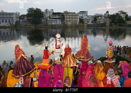 Rajasthani Frauen tragen Bildnisse von Shiva und seiner Frau Parvati auf dem GANGUR FESTIVAL UDAIPUR RAJASTHAN Indien Stockfoto