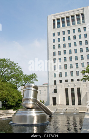 COLUMBUS, Ohio, USA – das Gerichtsgebäude in Columbus mit einer großen Hammerskulptur im Vordergrund, in einem Brunnen. Dieses eindrucksvolle Kunstwerk aus Edelstahl symbolisiert Gerechtigkeit und befindet sich im Ohio Judicial Center, dem Sitz des Supreme Court of Ohio. Stockfoto