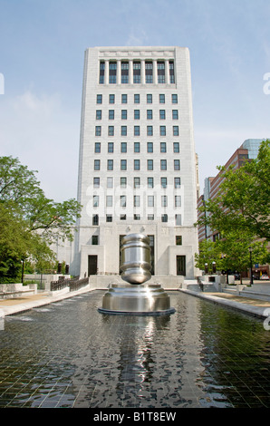 COLUMBUS, Ohio, USA – das Gerichtsgebäude in Columbus mit einer großen Hammerskulptur im Vordergrund, in einem Brunnen. Dieses eindrucksvolle Kunstwerk aus Edelstahl symbolisiert Gerechtigkeit und befindet sich im Ohio Judicial Center, dem Sitz des Supreme Court of Ohio. Stockfoto