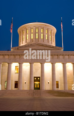 Ohio Statehouse in der Abenddämmerung Columbus // COLUMBUS, Ohio – das Ohio Statehouse, auch bekannt als Ohio State Capitol Building, steht in der Abenddämmerung am Capitol Square. Die griechische Wiedergeburt, die zwischen 1839 und 1861 erbaut wurde, dient als Sitz der Legislative des Bundesstaates Ohio. Die Westfassade des historischen Gebäudes zeigt klassische Säulen und einen markanten konischen Turm anstelle der traditionellen Kuppel, die auf vielen anderen Staatskapitolen zu finden ist. Stockfoto