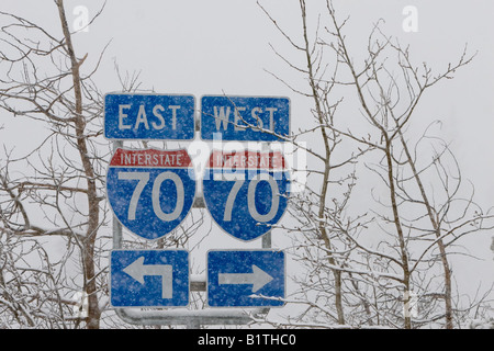 Ein Schneesturm verdunkelt die Zeichen für Interstate Highway 70 in den Bergen von Colorado. Stockfoto
