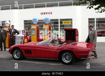 Murray Walker zieht sorgfältig in seinen roten Ferrari-275GTB an die Super Shell Zapfsäulen an Färberwaid Ecke Garage, Goodwood. Stockfoto