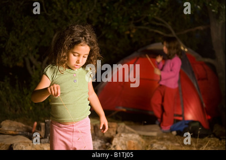 zwei Mädchen in einem Campingplatz bei Nacht Stockfoto