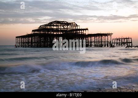 Die Sonne geht über Brightons West Pier bei Ebbe Stockfoto