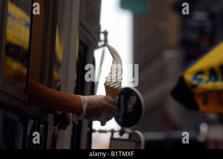 Eis-Liebhaber genießen einen Kegel Softeis von einem Herr Softee LKW an der Wall Street in New York Stockfoto