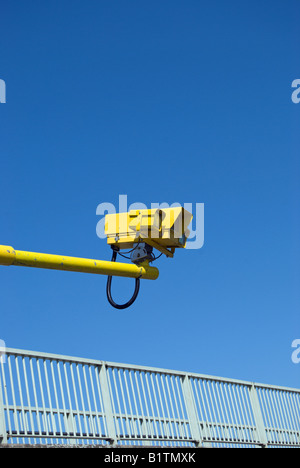 gesehen vor einem blauen Himmel, Uhren eine gelbe cctv-Kamera auf einem gelben Arm Verkehr auf der A316 Straße im Südwesten von london Stockfoto