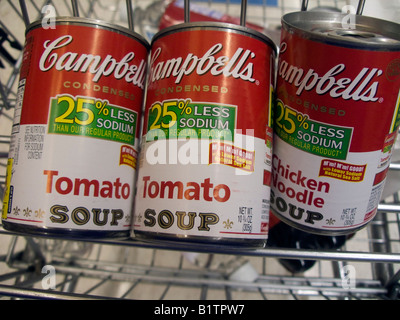Dosen von Campbell s Tomaten und Hühnchen Nudelsuppe in einem Lebensmittelgeschäft Wagen in einem Supermarkt in New York zu sehen sind Stockfoto