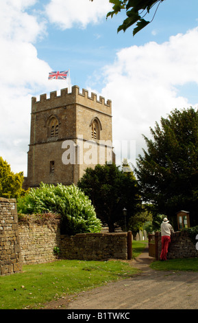 Guiting Power Dorfkirche Cotswolds Gloucestershire England am Gate ein Mann liest ein schwarzes Brett Stockfoto