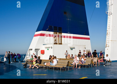 Passagiere sitzen draußen auf dem Deck auf eine Fährverbindung zwischen England und Frankreich Stockfoto