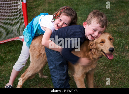 Kinder spielen mit ihrem Hund Stockfoto