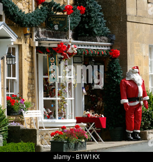 Weihnachtsmann außerhalb ein Weihnachts-Zubehör-Shop in den Cotswolds am Broadway Worcestershire England Stockfoto