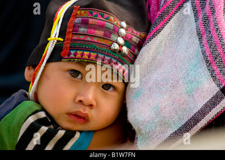 Ein Baby Akha Bergvolk Kind ruht auf der Schulter seiner Mutter in der burmesischen Grenze Stadt Tachilek. Stockfoto