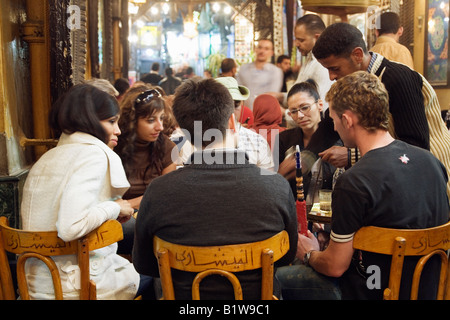 Kairo, Ägypten. Junge Touristen mit Wasserleitung in Fishawi s Kaffeehaus, Khan al Khalili Markt Stockfoto