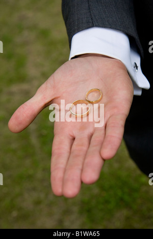 Gold Trauringe statt in den besten mans Hand. Stockfoto