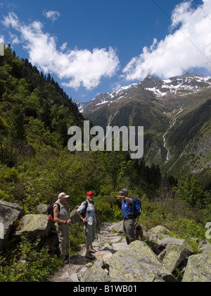 Ein Bergführer leitet zwei ältere Wanderer auf dem Weg zu der Sulzenaualm an der Spitze des Stubaitales österreichischen Tirol Stockfoto