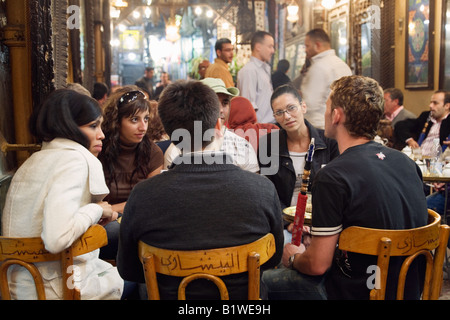 Kairo, Ägypten. Junge Touristen mit Wasserleitung in Fishawi s Kaffeehaus, Khan al Khalili Markt Stockfoto