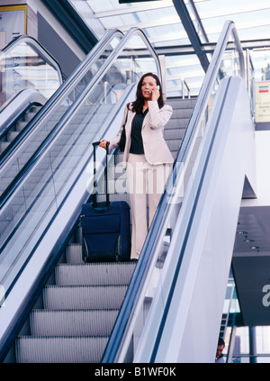 Frau auf dem Handy bei Rolltreppe Stockfoto