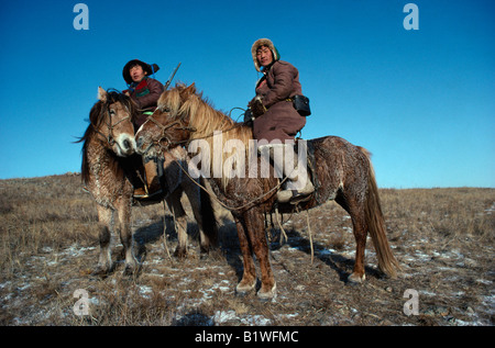 Mongolei Transport zwei Wolf Jäger auf Mountredon Ponys im Herbst mit Frost auf dem Boden Stockfoto