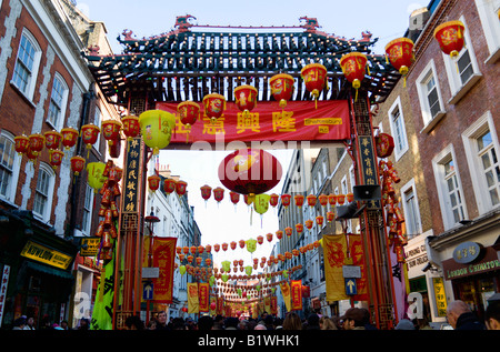 ENGLAND London Chinatown Menschenmengen durchlaufen ornamentalen Tor in der Gerrard Street beim chinesischen Neujahrsfest Stockfoto