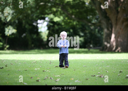 Blonde behaarte junge hält einen Stock spielen im Park. Stockfoto