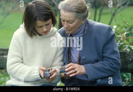 junges Mädchen zeigt ihre Großmutter wie Sie ein Mobiltelefon verwenden Stockfoto