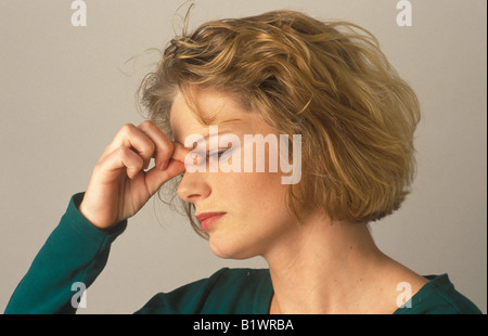 Frau mit die Brücke der Nase kneifen Kopfschmerzen Stockfoto