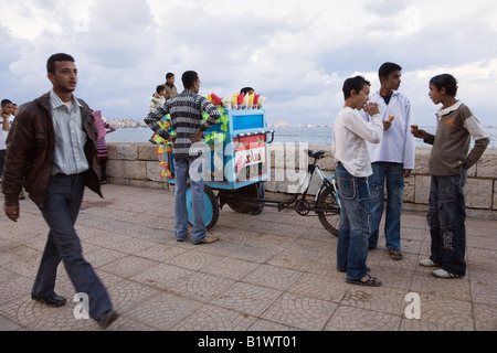 ALEXANDRIA ÄGYPTEN AFRIKA jungen Männer und Eis auf der Promenade östlichen Hafen Mittelmeer im Hintergrund Abschaltdruck Stockfoto