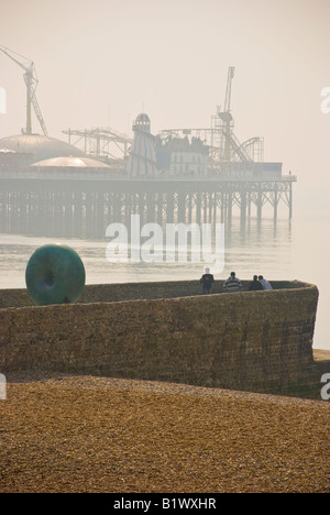 Brighton Pier im Morgennebel Ealy mit drei Figuren Stockfoto