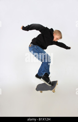 Skateboarder machen einen Kickflip mit seinem Schuss in Begleitung an Bord und isoliert auf weiss Stockfoto