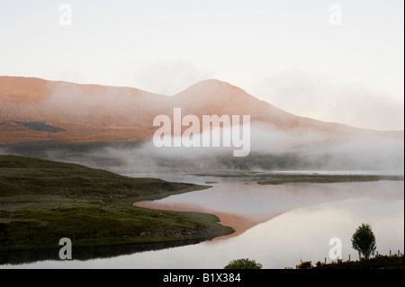 Am frühen Morgennebel und Wolken über Loch Achanalt, Highlands, Schottland Stockfoto