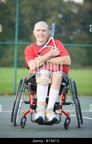 Porträt eines älteren Mannes in einem Rollstuhl sitzt und hält einen Tennisschläger Stockfoto