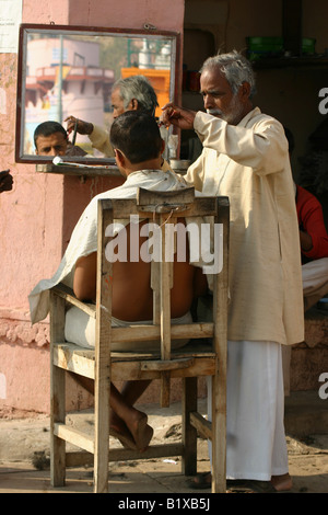 Barbier, indem Sie eine Haare schneiden auf einem Ghat, varanasi Stockfoto