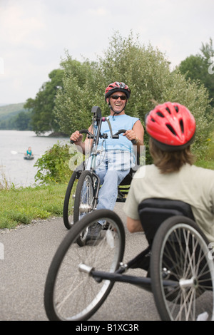 Junger Mann und eine junge Frau, die adaptive Fahrrad fahren Stockfoto