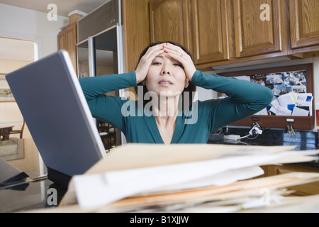 Geschäftsfrau Dateien betrachten und hielt ihren Kopf Stockfoto