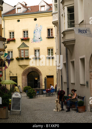 Straßenszene mit Cafés Personen und einem Hund in Schlossegasse in Hall in Tirol Österreich Stockfoto