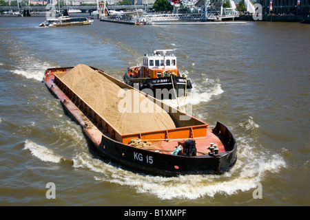 Schlepper drückt Kahn voller Sand der Themse in London Stockfoto