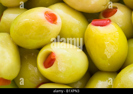 Makro-Porträt von grünen Oliven gefüllt mit Paprika rot Stockfoto