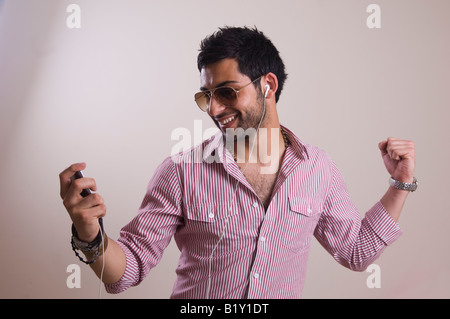 Glücklich ethnischen Jüngling hören und tanzen zur Musik auf Ipod MP3-player Stockfoto