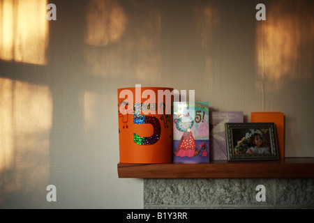 Kaminsims über Kamin mit fünften Geburtstag festliche Hut und Karten Stockfoto