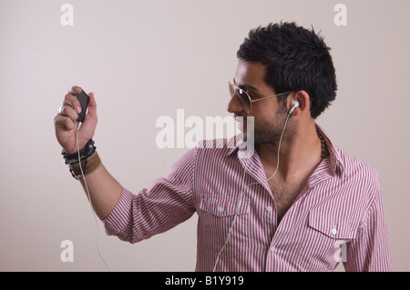 Glücklich ethnischen Jüngling hören und tanzen zur Musik auf Ipod MP3-player Stockfoto