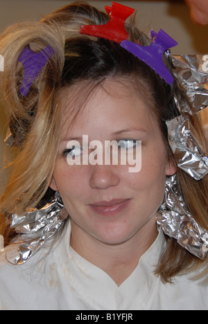 Eine Frau bekommt ihr Haar mit Folie hervorgehoben. Stockfoto