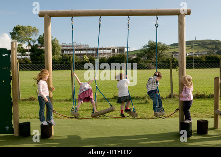 fünf 5 Grundschulkinder im Freien in Spielplatz spielen auf Seil Übung Klettergerüst, Aberystwyth Wales UK Stockfoto